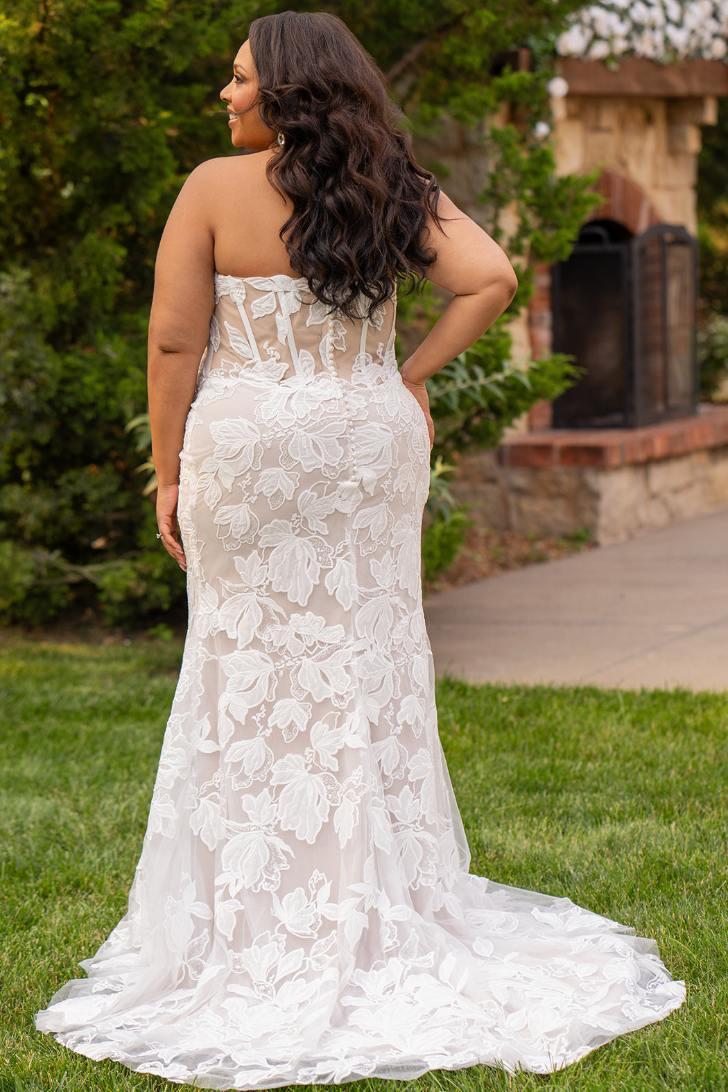 Michelle Bridal MB2603 in Ivory/ Cappuccino. 
Strapless fitted gown with a natural waistline and center back zipper. Sweetheart neckline, soft bridal tulle and large floral applique. Exposed back boning, covered buttons and optional back panel. 