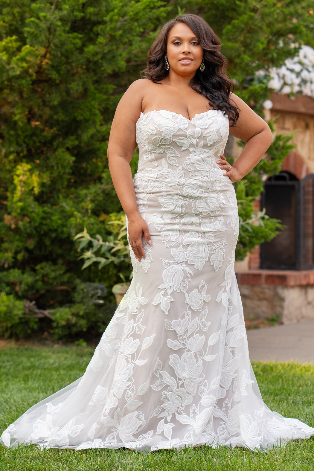 Michelle Bridal MB2603 in Ivory/ Cappuccino. 
Strapless fitted gown with a natural waistline and center back zipper. Sweetheart neckline, soft bridal tulle and large floral applique. Exposed back boning, covered buttons and optional back panel. 