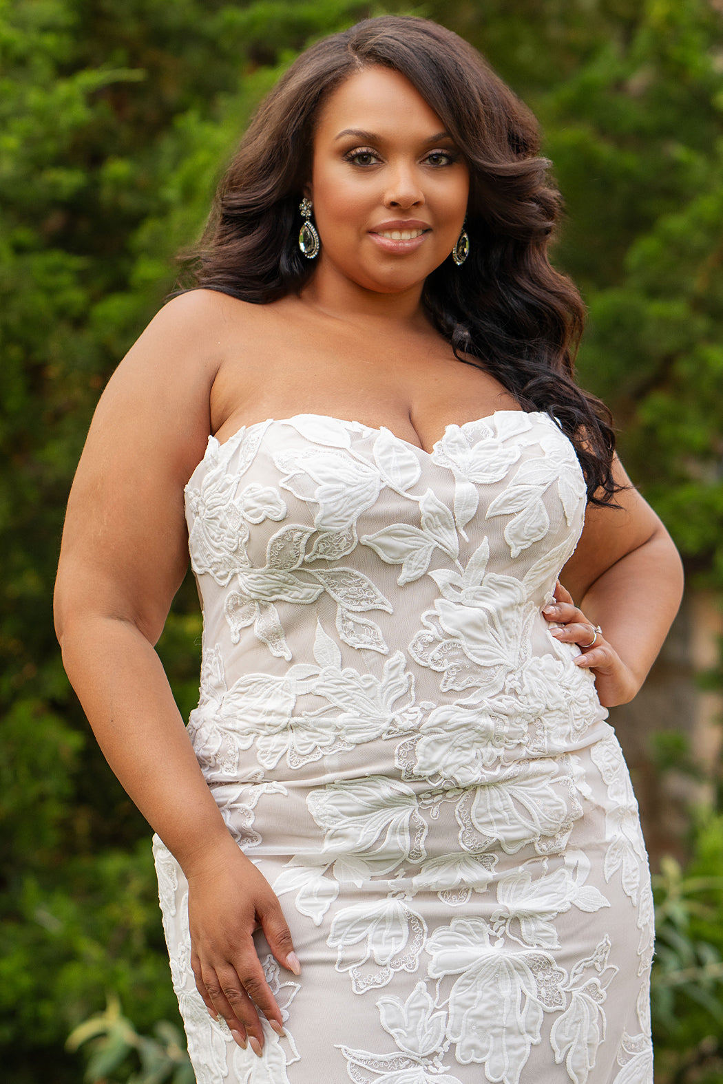 Michelle Bridal MB2603 in Ivory/ Cappuccino. 
Strapless fitted gown with a natural waistline and center back zipper. Sweetheart neckline, soft bridal tulle and large floral applique. Exposed back boning, covered buttons and optional back panel. 
