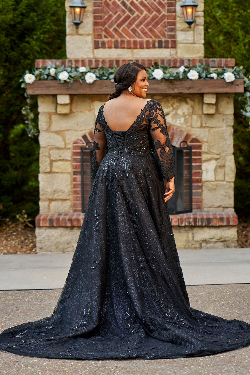 MB2604 by Michelle Bridal

Available in Black, Ivory, Black on Ivory, Ivory on Black, Ivory on Champagne and Black on Champagne. 

Plus-size model wearing a black A-line wedding gown with sheer long sleeves, a deep V-neckline, and intricate lace appliqué with subtle shimmer throughout the full skirt, photographed outdoors in front of a stone backdrop.