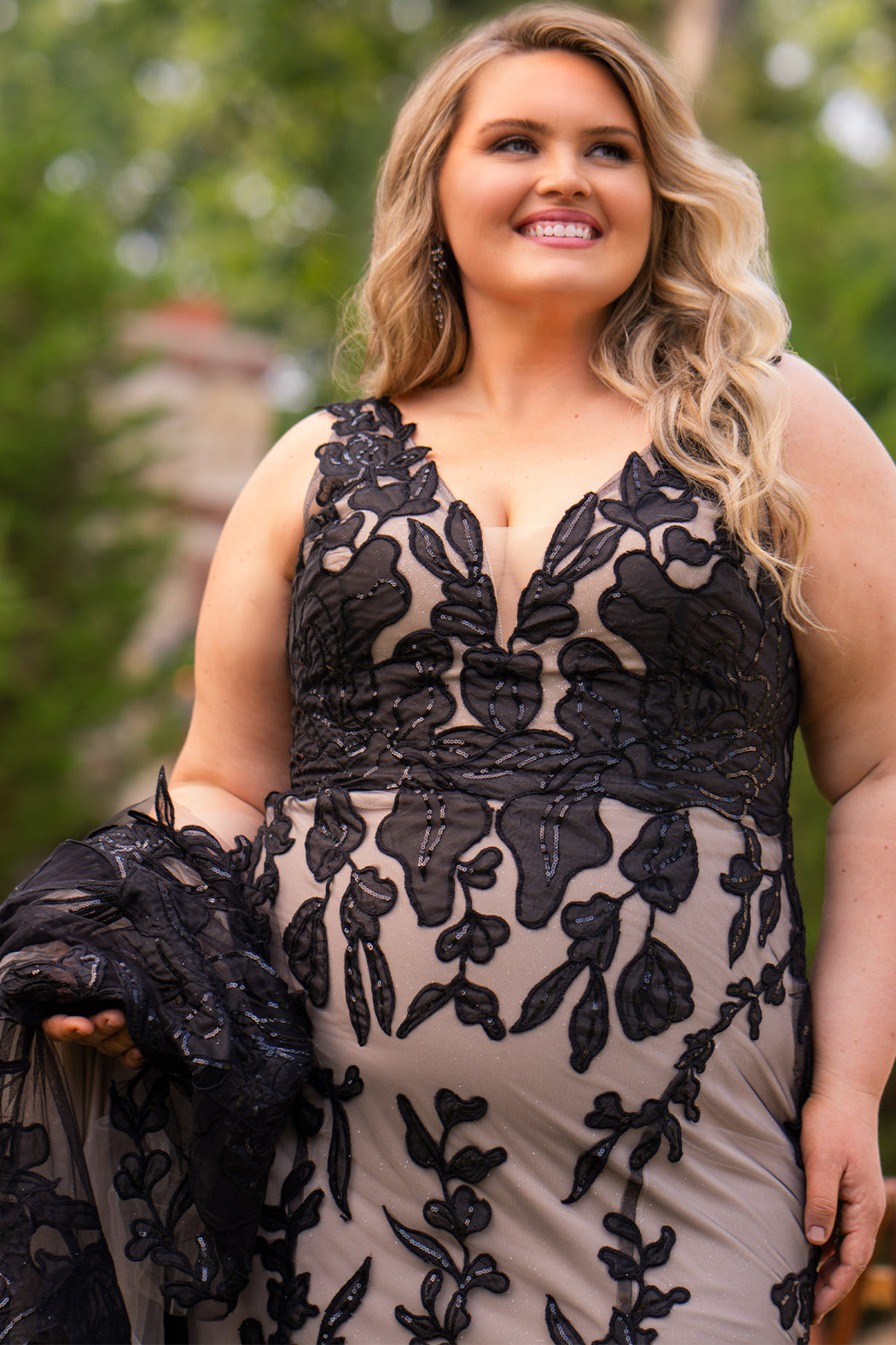 Michelle Bridal MB2606 in black/champagne. Fitted gown with bra-friendly straps, natural waistline, v-neckline, scoop lace back and center back zipper. Black Soft tulle, floral organza appliques over a champagne stretch knit lining. Train.