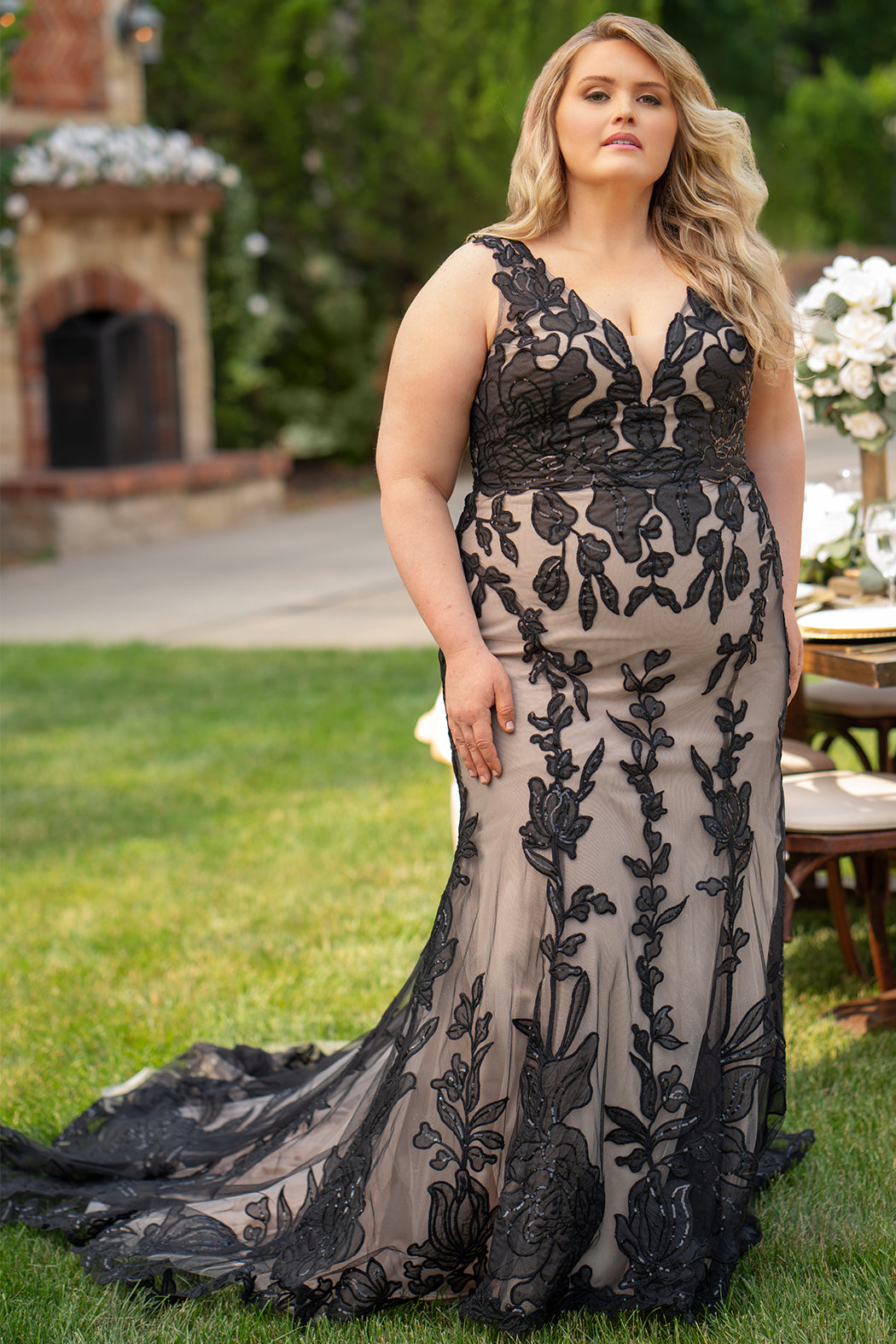 Michelle Bridal MB2606 in black/champagne. Fitted gown with bra-friendly straps, natural waistline, v-neckline, scoop lace back and center back zipper. Black Soft tulle, floral organza appliques over a champagne stretch knit lining. Train.