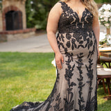 Michelle Bridal MB2606 in black/champagne. Fitted gown with bra-friendly straps, natural waistline, v-neckline, scoop lace back and center back zipper. Black Soft tulle, floral organza appliques over a champagne stretch knit lining. Train.