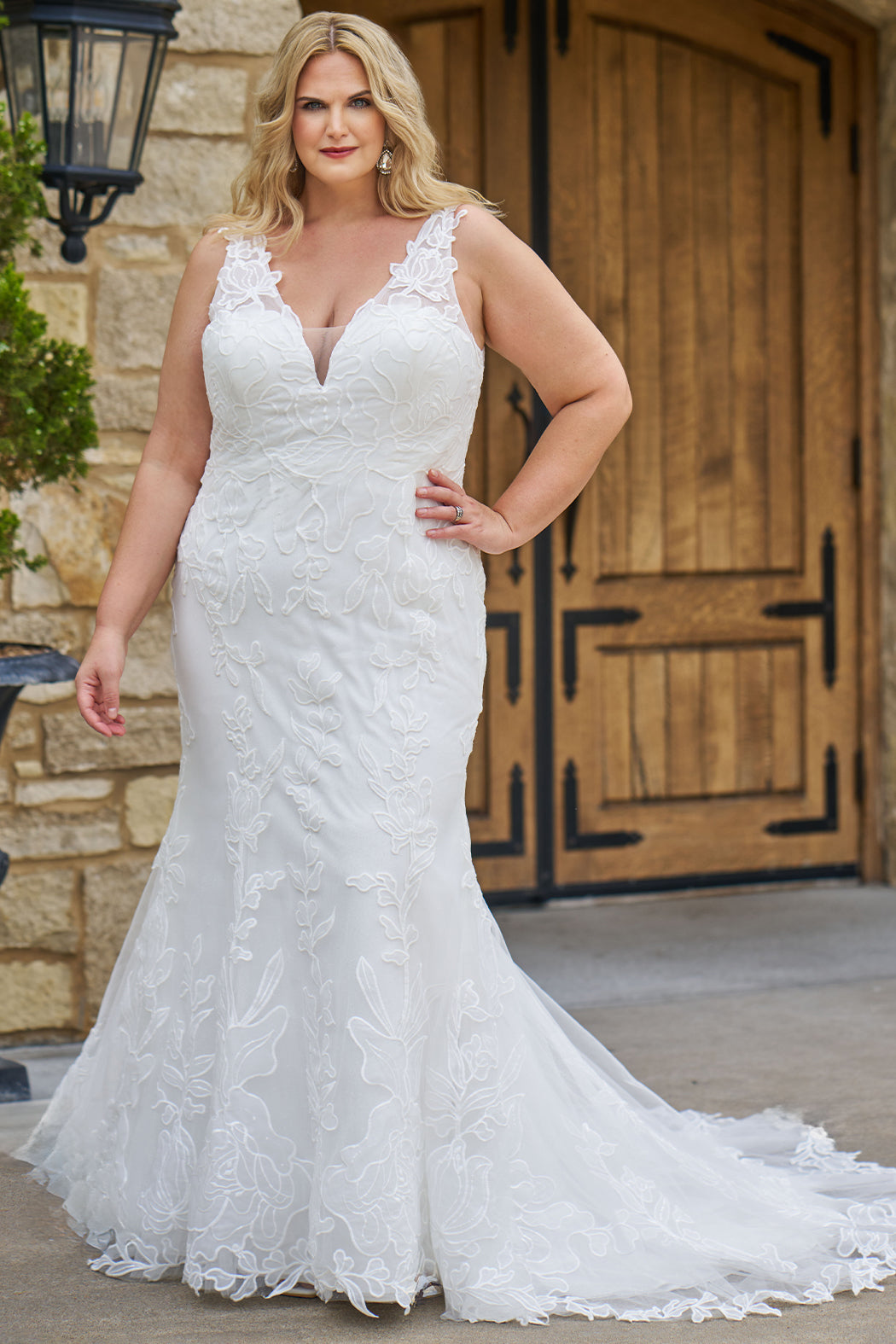 Michelle Bridal MB2606 in ivory. Fitted gown with bra-friendly straps, natural waistline, v-neckline, scoop lace back and center back zipper. Black Soft tulle, floral organza appliques over a champagne stretch knit lining. Train.