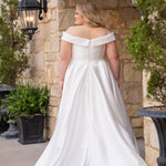 Michelle Bridal MB2610 shown in ivory. Off-the-shoulder satin A-line gown, bodice cuff covered in pearls and clear beads. Natural waistline, box pleats on skirt and center back zipper. Long satin train. 