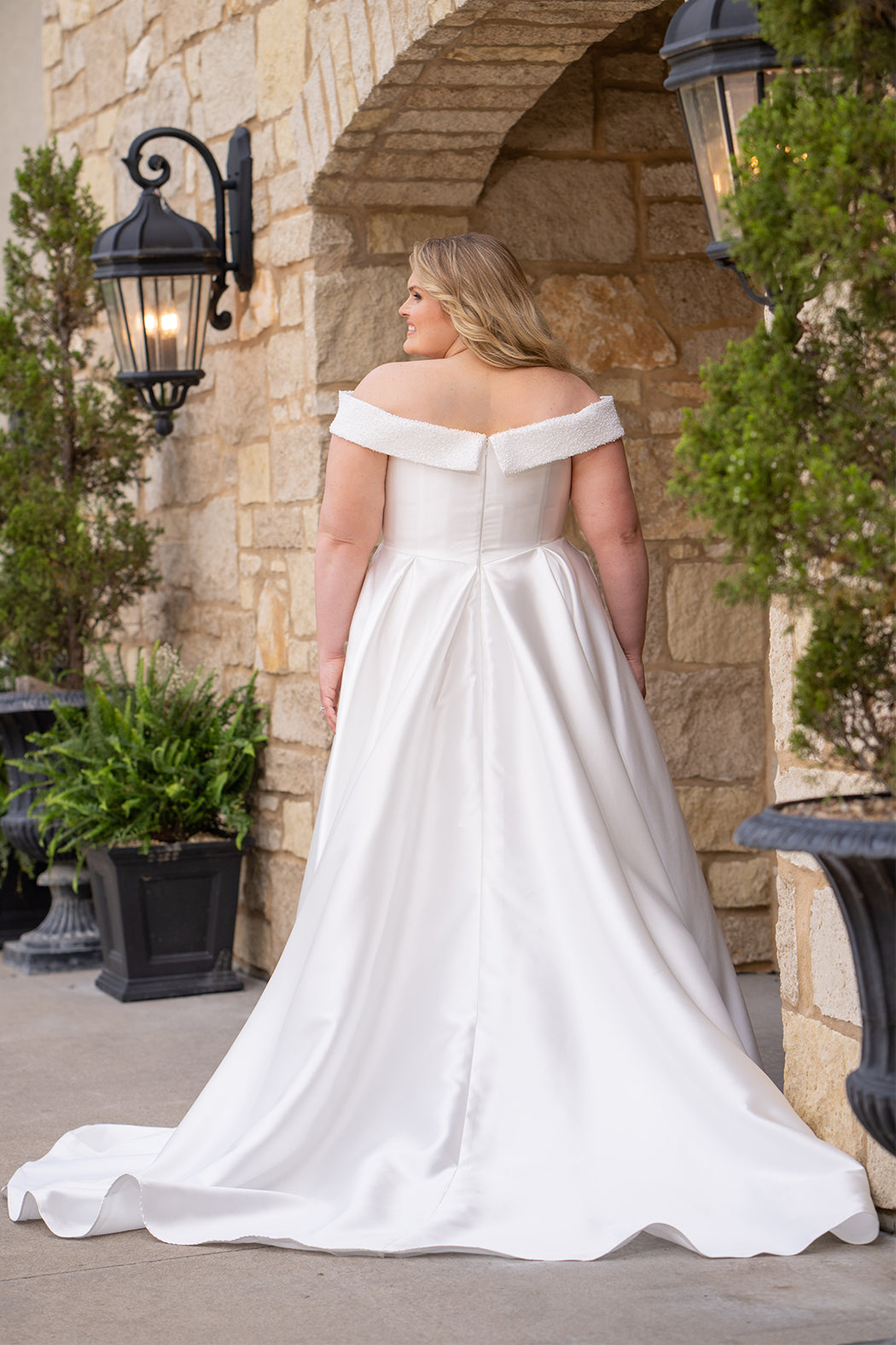 Michelle Bridal MB2610 shown in ivory. Off-the-shoulder satin A-line gown, bodice cuff covered in pearls and clear beads. Natural waistline, box pleats on skirt and center back zipper. Long satin train. 