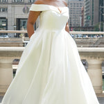 Michelle Bridal MB2610 shown in ivory. Off-the-shoulder satin A-line gown, bodice cuff covered in pearls and clear beads. Natural waistline, box pleats on skirt and center back zipper. Long satin train. 