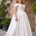 Michelle Bridal MB2610 shown in ivory. Off-the-shoulder satin A-line gown, bodice cuff covered in pearls and clear beads. Natural waistline, box pleats on skirt and center back zipper. Long satin train. 