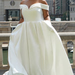 Michelle Bridal MB2610 shown in ivory. Off-the-shoulder satin A-line gown, bodice cuff covered in pearls and clear beads. Natural waistline, box pleats on skirt and center back zipper. Long satin train. 