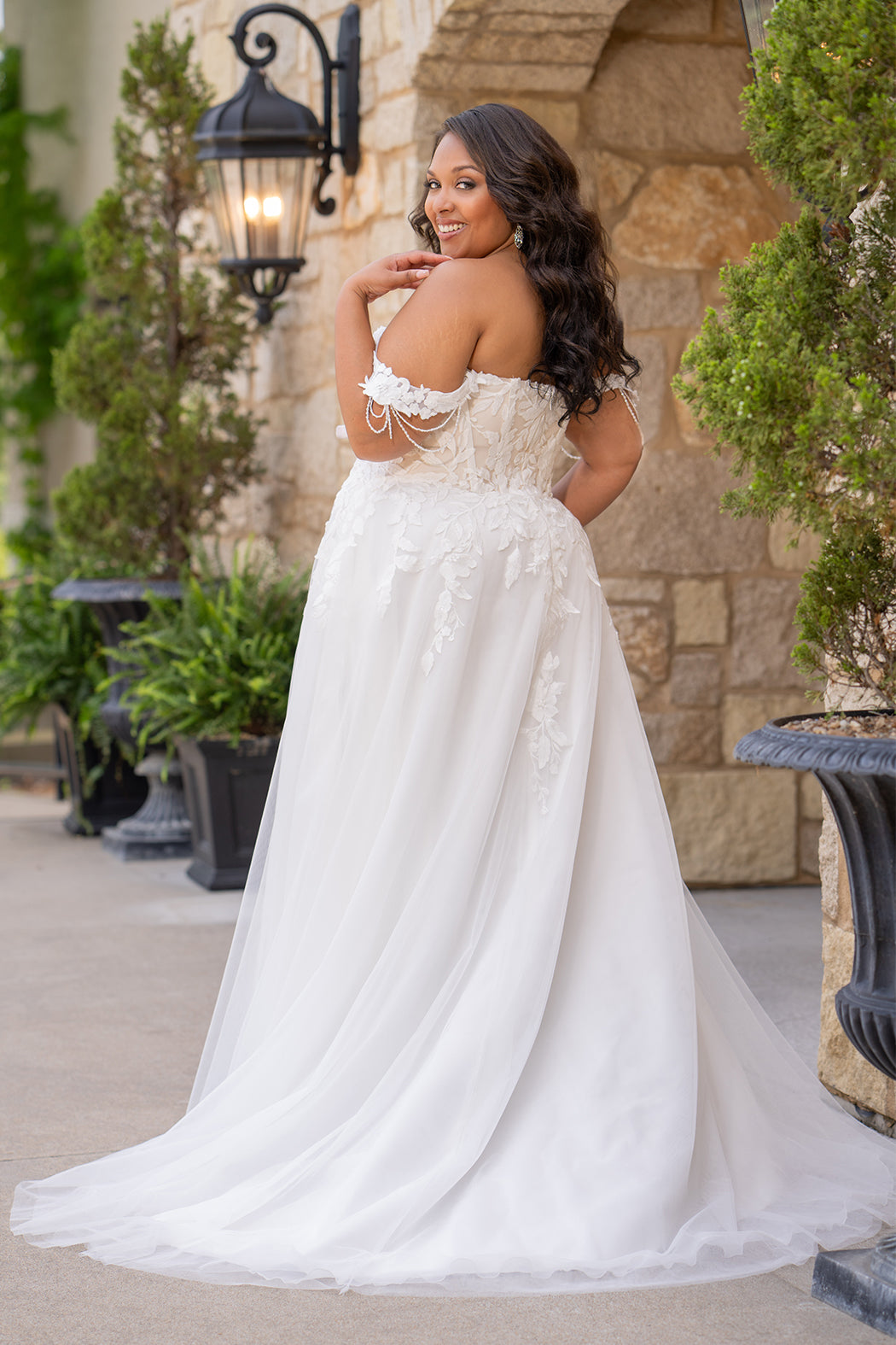 Michelle Bridal MB2611 shown in Ivory/Nude. 
Strapless bodice with deep v-neckline, exposed boning and optional drape straps with beaded detail. Soft bridal tulle A-line skirt with floral appliques, center back zipper. 
