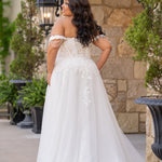 Michelle Bridal MB2611 shown in Ivory/Nude. 
Strapless bodice with deep v-neckline, exposed boning and optional drape straps with beaded detail. Soft bridal tulle A-line skirt with floral appliques, center back zipper. 