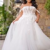 Michelle Bridal MB2611 shown in Ivory/Nude. 
Strapless bodice with deep v-neckline, exposed boning and optional drape straps with beaded detail. Soft bridal tulle A-line skirt with floral appliques, center back zipper. 