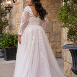 Michelle Bridal MB2612 shown in Ivory/Rosewater. 

Long sleeve tulle A-line, lace covered bodice, v-neckline and 5 inch waistband. Flowy tulle skirt with slit, satin lining and scattered lace appliques. V-back and center back zipper. 