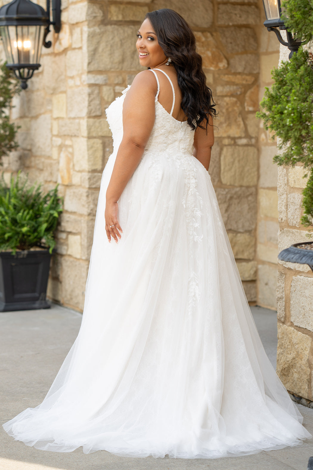 Michelle Bridal MB2613 shown in Ivory. 
Beaded double spaghetti straps, v-neckline, natural waistline. 3D floral appliques, soft bridal tulle, satin lining. A-Line skirt with left leg slit. Scoop back and center back zipper. 