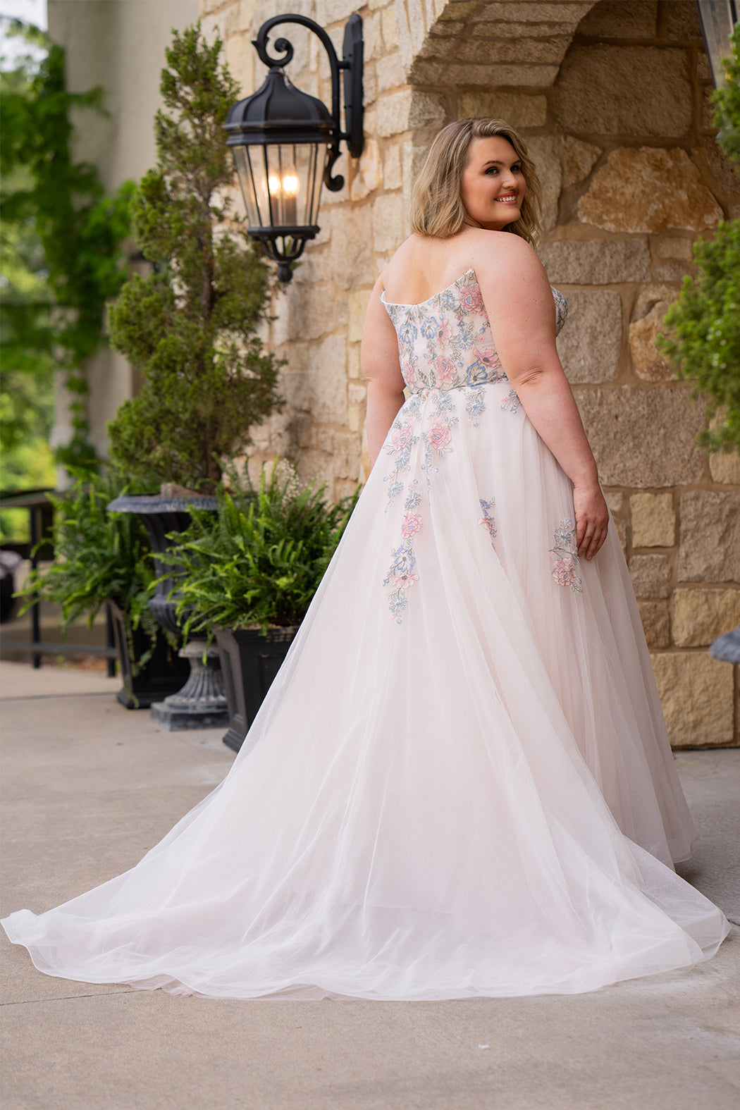 Michelle Bridal MB2614 in Floral. 
Strapless scoop bodice, cat eye detail, pink and blue floral appliques. Natural waistline, A-line skirt, tulle and sparkle tulle layers over lightweight soft pink satin lining. Horse hair hem, scoop back and center back zipper. 