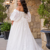 Michelle Bridal MB2618 shown in Ivory. 

Strapless sweetheart ballgown. Soft bridal tulle, floral lace appliques, lightweight satin lining. Natural waistline, A-Line skirt. Bicep optional puff sleeves. Straight across back, center back zipper, train and covered buttons. 