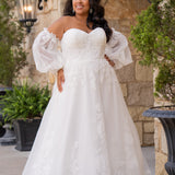 Michelle Bridal MB2618 shown in Ivory. 

Strapless sweetheart ballgown. Soft bridal tulle, floral lace appliques, lightweight satin lining. Natural waistline, A-Line skirt. Bicep optional puff sleeves. Straight across back, center back zipper, train and covered buttons. 