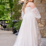 Michelle Bridal MB2618 shown in Sand. 

Strapless sweetheart ballgown. Soft bridal tulle, floral lace appliques, lightweight satin lining. Natural waistline, A-Line skirt. Bicep optional puff sleeves. Straight across back, center back zipper, train and covered buttons. 