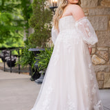 Michelle Bridal MB2618 shown in Sand. 

Strapless sweetheart ballgown. Soft bridal tulle, floral lace appliques, lightweight satin lining. Natural waistline, A-Line skirt. Bicep optional puff sleeves. Straight across back, center back zipper, train and covered buttons. 