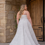 Michelle Bridal MB2619 shown in Ivory. 

Strapless straight across neckline with 3 inch bodice fold over cuff. Soft brocade gown with princess seams and no defined waistline. A-line skirt, horsehair hem, long train and center back zipper. 