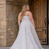 Michelle Bridal MB2619 shown in Ivory. 

Strapless straight across neckline with 3 inch bodice fold over cuff. Soft brocade gown with princess seams and no defined waistline. A-line skirt, horsehair hem, long train and center back zipper. 