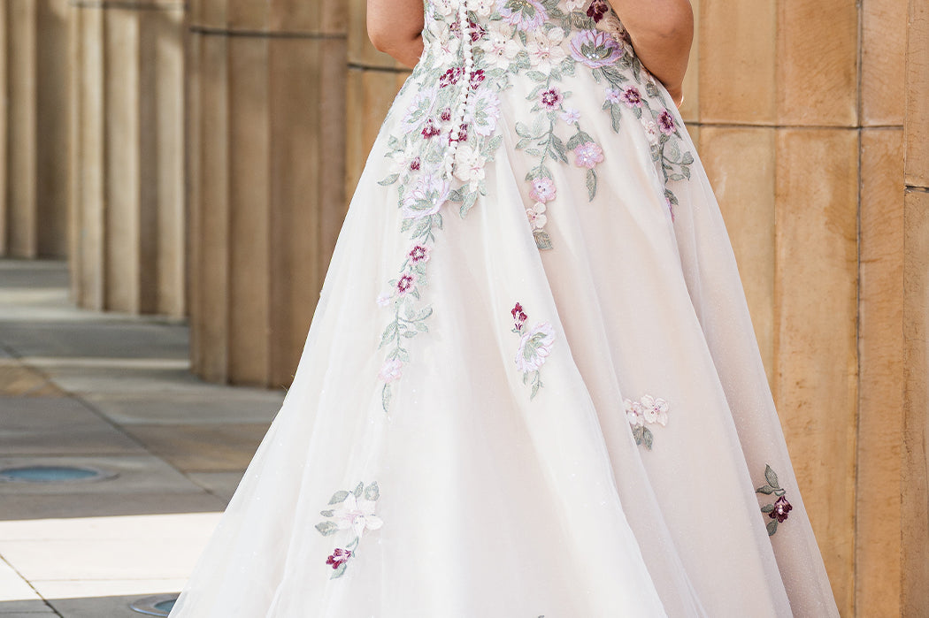 Michelle Bridal MB2622 shown in Floral Champagne. 

Ballgown with thick bra-friendly straps. V-neck, natural waistline, ballgown skirt, multi colored floral appliques, soft tulle and satin lining. Long train and center back zipper with covered buttons. 