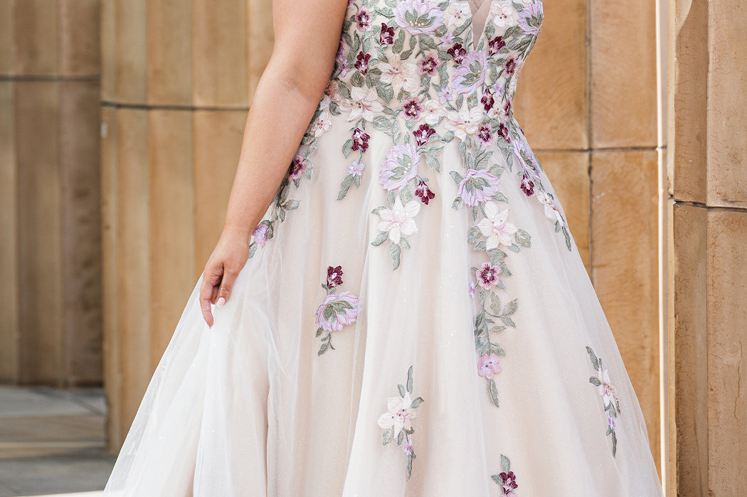 Michelle Bridal MB2622 shown in Floral Champagne. 

Ballgown with thick bra-friendly straps. V-neck, natural waistline, ballgown skirt, multi colored floral appliques, soft tulle and satin lining. Long train and center back zipper with covered buttons. 