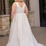 Michelle Bridal MB2625 shown in Ivory. 

Organza brocade A-line silhouette, Pleated faux surplice bodice for elegant shaping, Bra-friendly straps and sleeveless, detachable belt with oversized bow for two looks in one, Box-pleated A-line skirt with front slit for movement, Chapel-length train for timeless finish, Invisible center back zipper.