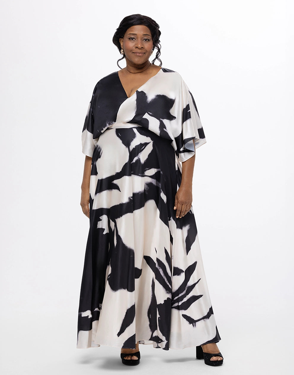 Woman wearing a black and white patterned dress on a white background