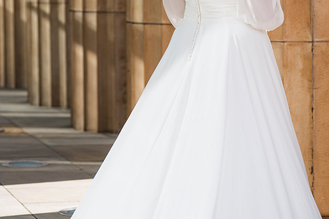 Sydney's Closet SC5320 ivory. Bridal chiffon, Satin lining, Silhouette: A-line, Neckline: V-neckline, Lightly pleated bodice, Bra-friendly straps, Long sleeves with cuff, Fully lined, Natural waistline, V-back, Long invisible center back zipper.