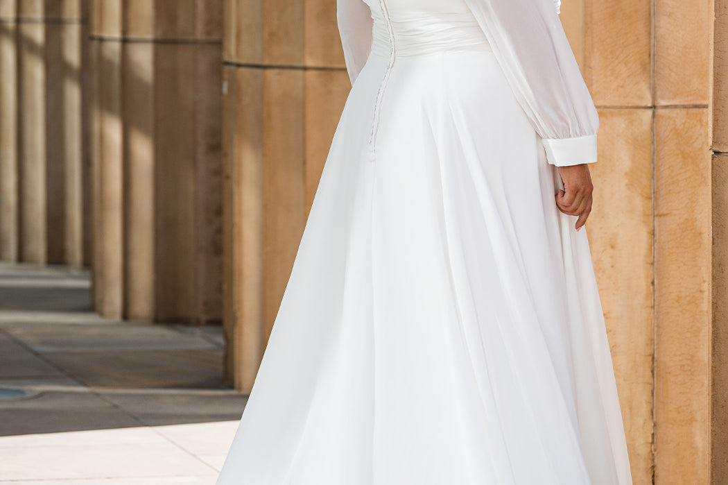 Sydney's Closet SC5320 ivory. Bridal chiffon, Satin lining, Silhouette: A-line, Neckline: V-neckline, Lightly pleated bodice, Bra-friendly straps, Long sleeves with cuff, Fully lined, Natural waistline, V-back, Long invisible center back zipper.