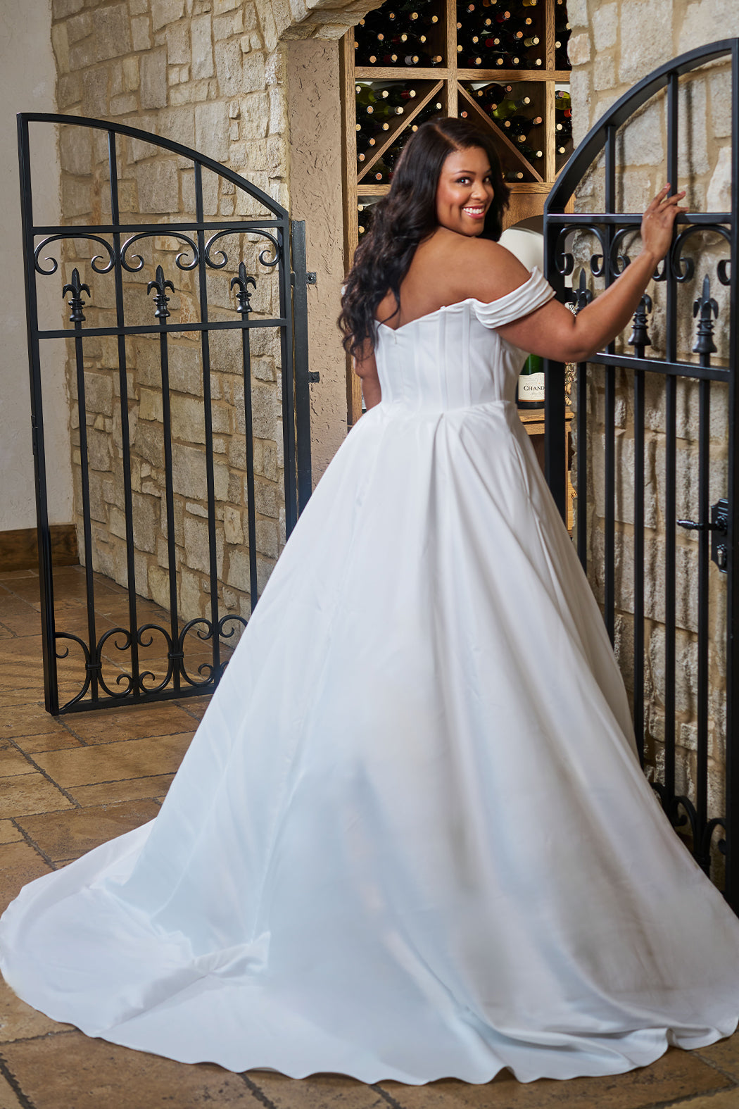 Plus size classic and simple wedding dress. Style SC5347 by Sydney's Closet.  Strapless sweetheart neckline with pleated bust and pleated off-the-shoulder sleeves. Exposed corset boning on a basque waist with full A-line skirt, box pleats, pockets and a long train. Available in black or ivory in curvy sizes 14-32.