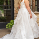 Woman in a white wedding dress standing outdoors near a stone wall.

Sydney's Closet style SC5359 pleated organza bridal gown with tiered ball gown skirt.
