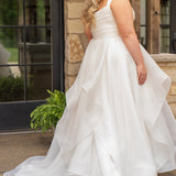 Woman in a white wedding dress standing outdoors near a stone wall.

Sydney's Closet style SC5359 pleated organza bridal gown with tiered ball gown skirt.