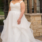 Woman in a white wedding dress standing outdoors near a stone wall.

Sydney's Closet style SC5359 pleated organza bridal gown with tiered ball gown skirt.
