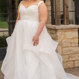 Woman in a white wedding dress standing outdoors near a stone wall.

Sydney's Closet style SC5359 pleated organza bridal gown with tiered ball gown skirt.