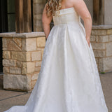 Plus size floral brocade wedding dress style SC5263 from designer Sydney's Closet.  Strapless, straight across neckline with folded cuff detail. Full A-line skirt with box pleats, crinoline and pockets. Long train and center back zipper. 