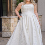 Plus size floral brocade wedding dress style SC5263 from designer Sydney's Closet.  Strapless, straight across neckline with folded cuff detail. Full A-line skirt with box pleats, crinoline and pockets. Long train and center back zipper. 