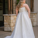 Plus size floral brocade wedding dress style SC5263 from designer Sydney's Closet.  Strapless, straight across neckline with folded cuff detail. Full A-line skirt with box pleats, crinoline and pockets. Long train and center back zipper. 