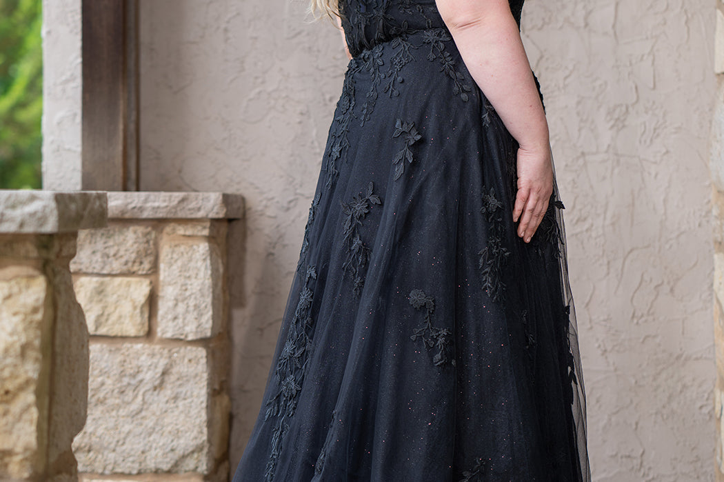 Sydney's Closet SC5372 plus size wedding dress.  Black floral lace on black tulle. Sexy plunging V-neckline with exposed corset boning.  Basque waistline on A-line skirt with slit and long train with lace details. Perfect for the unique, alternative bride. 