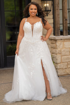 Sydney's Closet SC5372 plus size wedding dress.  Ivory floral lace on ivory tulle. Sexy plunging V-neckline with exposed corset boning.  Basque waistline on A-line skirt with slit and long train with lace details. 