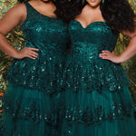 SC7398 & SC7399 duo picture with oversized candy for prom 2025. 

Strapless, sweetheart plus size gala formal ballgown. Exposed corset boning on bodice covered in lace applqiues. Tiered A-line skirt with matching lace applique hem. Style SC7398 is available in forest green, navy blue or burgundy red by Sydney's Closet. 

Plus size one-shoulder formal gala Mardi Gras gown with embroidered sequin lace appliques on bodice and on tiered A-line skirt with slit. Available in forest green. navy blue and burgundy r