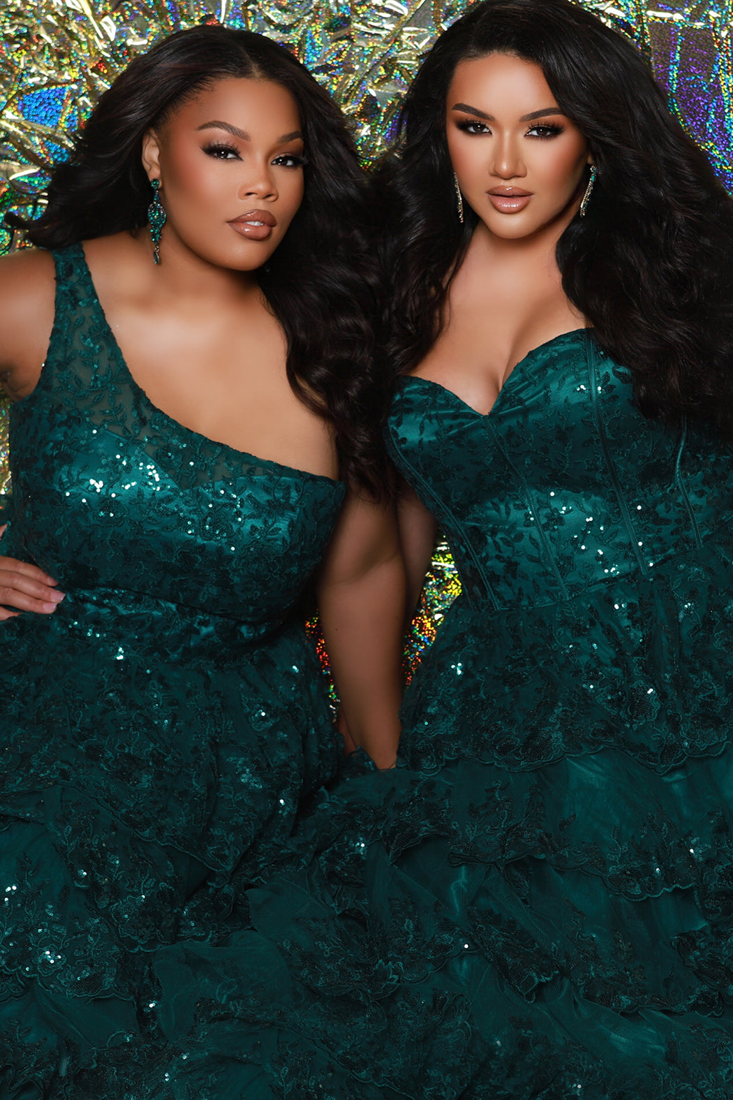 SC7398 & SC7399 duo picture with oversized candy for prom 2025. 

Strapless, sweetheart plus size gala formal ballgown. Exposed corset boning on bodice covered in lace applqiues. Tiered A-line skirt with matching lace applique hem. Style SC7398 is available in forest green, navy blue or burgundy red by Sydney's Closet. 

Plus size one-shoulder formal gala Mardi Gras gown with embroidered sequin lace appliques on bodice and on tiered A-line skirt with slit. Available in forest green. navy blue and burgundy r