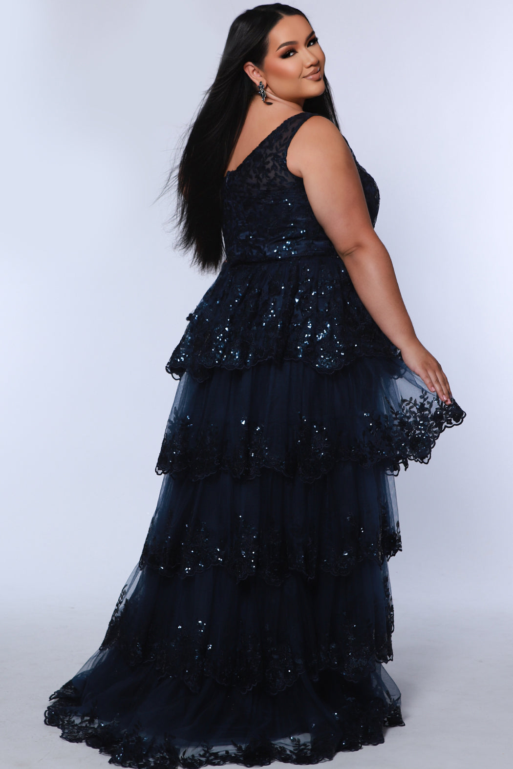 Plus size one-shoulder formal gala Mardi Gras gown with embroidered sequin lace appliques on bodice and on tiered A-line skirt with slit. Available in forest green. navy blue and burgundy red. Style SC7399 by Sydney's Closet. 