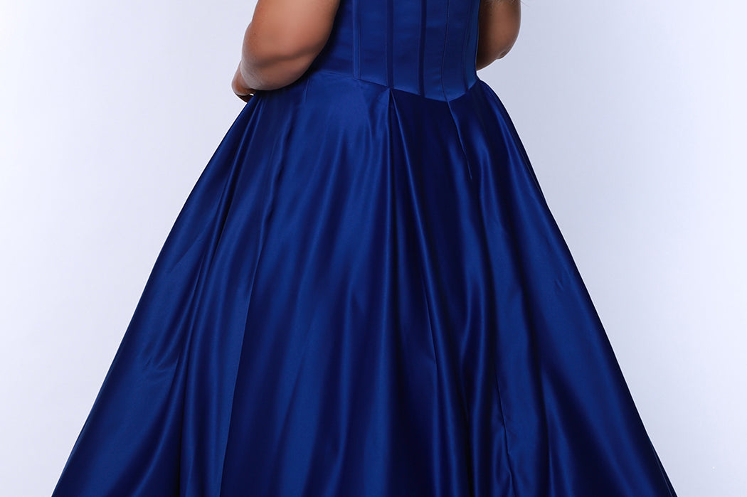 Long formal satin ballgown style SC7400 by Sydney's Closet. Available in sizes 14-32 in colors cobalt blue, onyx black and ruby red.  Pleated bodice with exposed boning, detachable pleated drape sleeves, basque waist and pockets.  
