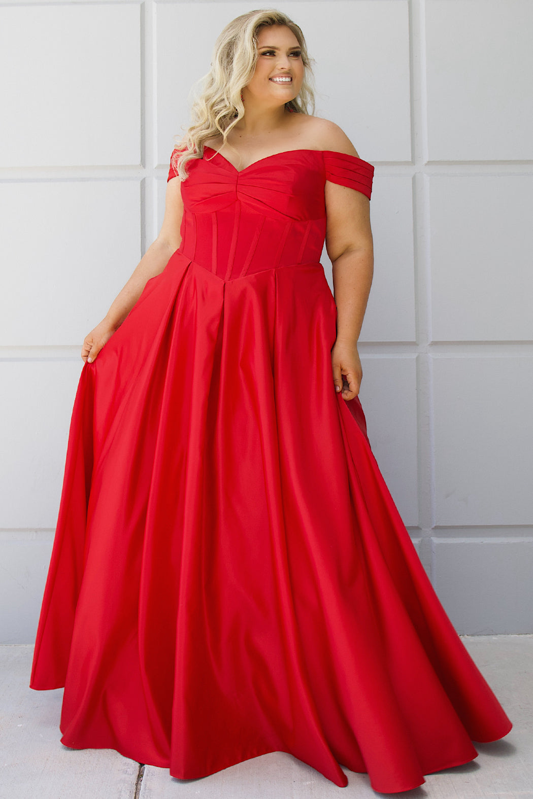 Long formal satin ballgown style SC7400 by Sydney's Closet. Available in sizes 14-32 in colors cobalt blue, onyx black and ruby red.  Pleated bodice with exposed boning, detachable pleated drape sleeves, basque waist and pockets.  
