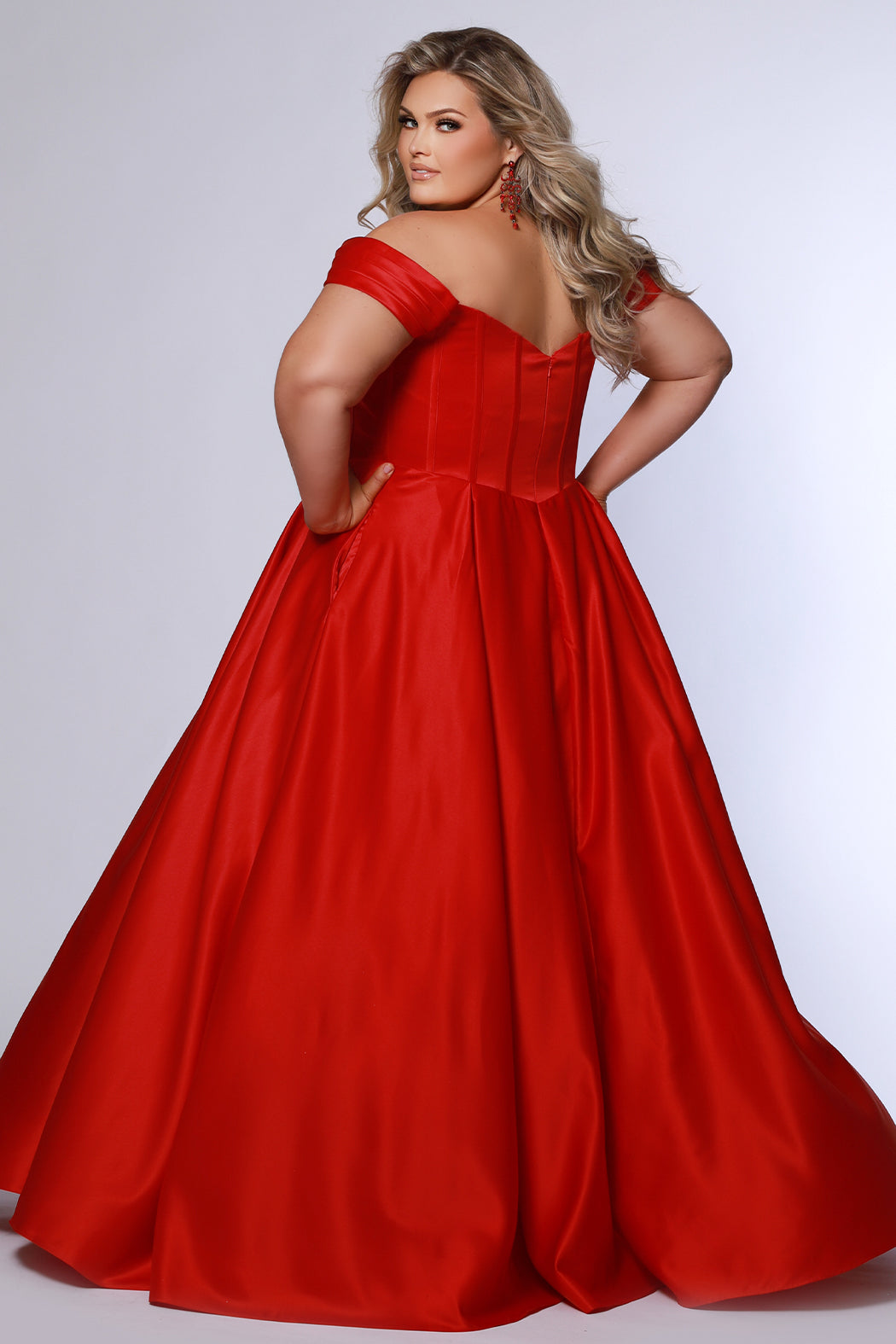 Long formal satin ballgown style SC7400 by Sydney's Closet. Available in sizes 14-32 in colors cobalt blue, onyx black and ruby red.  Pleated bodice with exposed boning, detachable pleated drape sleeves, basque waist and pockets.  