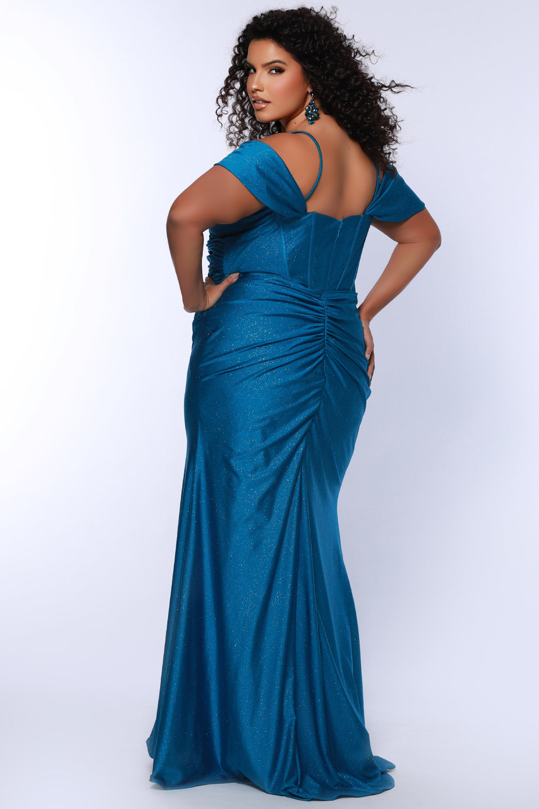 Sydney's Closet SC7402 sexy fitted prom dress in sparkle lycra .  Exposed boning on corset, drape sleeves with adjsutable spaghetti straps, high slit and ruchsed skirt. Available in violet purple, magenta pink, or turq blue and green. 
