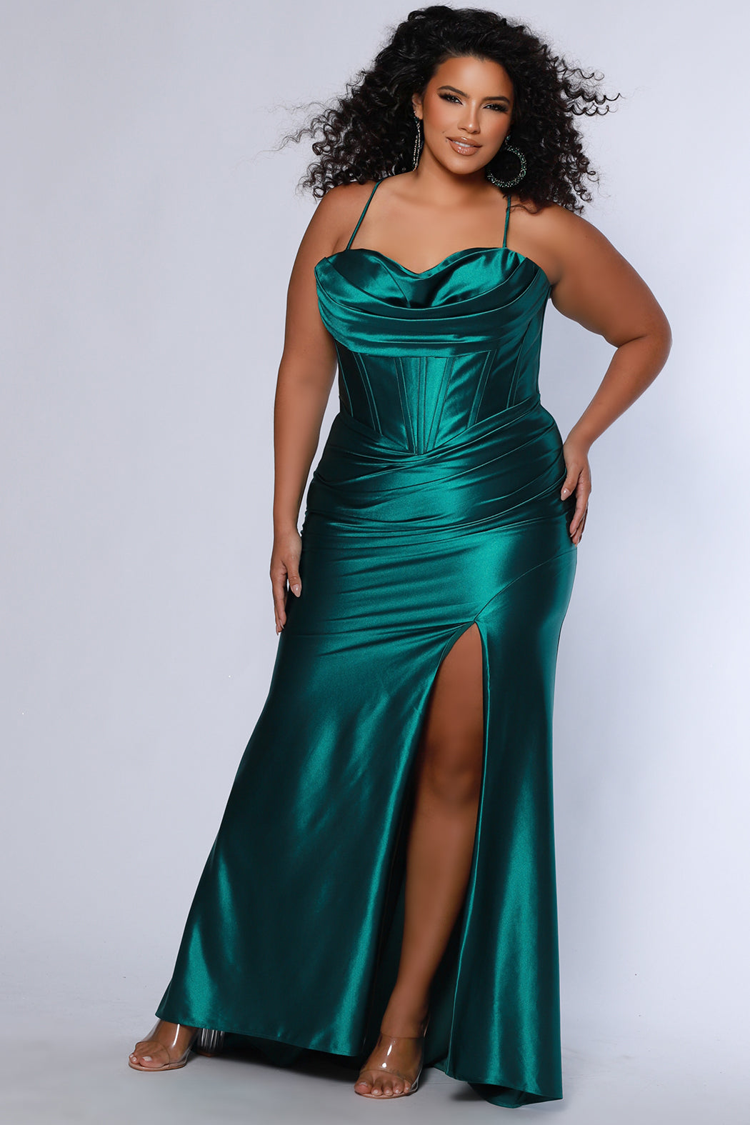 Simple plus size satin slim a-line fitted dress.  Spaghetti straps, pleated bodice, exposed boning corset with basque waistline.  Slim, fitted skirt with ruching. Lace-up back with modesty panel and sweep train.  Available in cherry red, chocolate brown, hunter green and onyx black. Sydney's Closet plus size style SC7426.