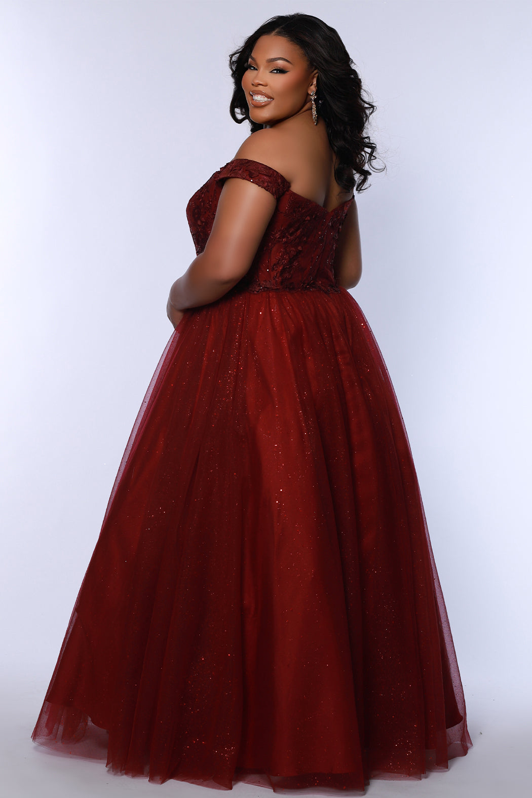 Plus size elegeant off-the-shoulder ball gown with 3D floral lace and sparkle tulle. Full A-line skirt and center back zipper. Availablie in burgundy red, onyx black and plum purple in plus sizes 14-40. Style SC7428 from Sydney's Closet.